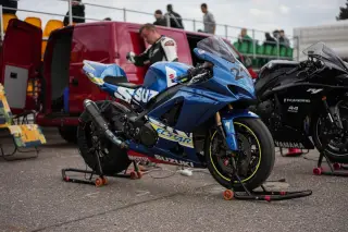 Ilustrasi: Sepeda motor balap warna biru terparkir di area paddock sirkuit.