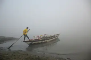 Ilustrasi: Seorang pria mendayung perahu kayu kecil di perairan berkabut tebal.