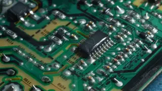 Ilustrasi: Tampilan jarak dekat papan sirkuit elektronik hijau dengan berbagai komponen dan cip.