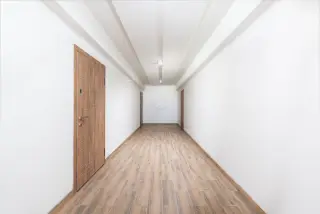 Ilustrasi: Lorong bangunan kosong dengan dinding putih bersih dan lantai bermotif kayu.