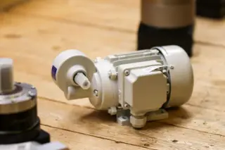 Ilustrasi: Motor listrik industri kecil diletakkan di atas permukaan meja kayu.