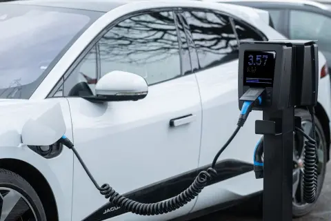 Ilustrasi: Mobil listrik putih sedang diisi daya pada stasiun pengisian baterai.
