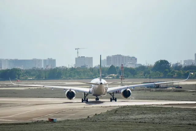 Ilustrasi: Tampak belakang pesawat komersial sedang melaju di landasan pacu bandara.